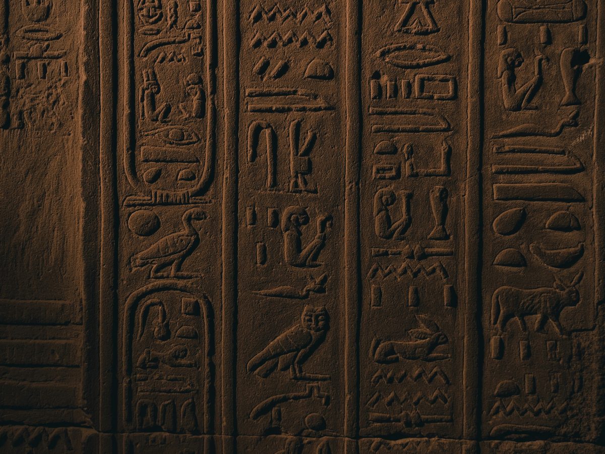 Detailed carved hieroglyphs and figures on an ancient Egyptian wall