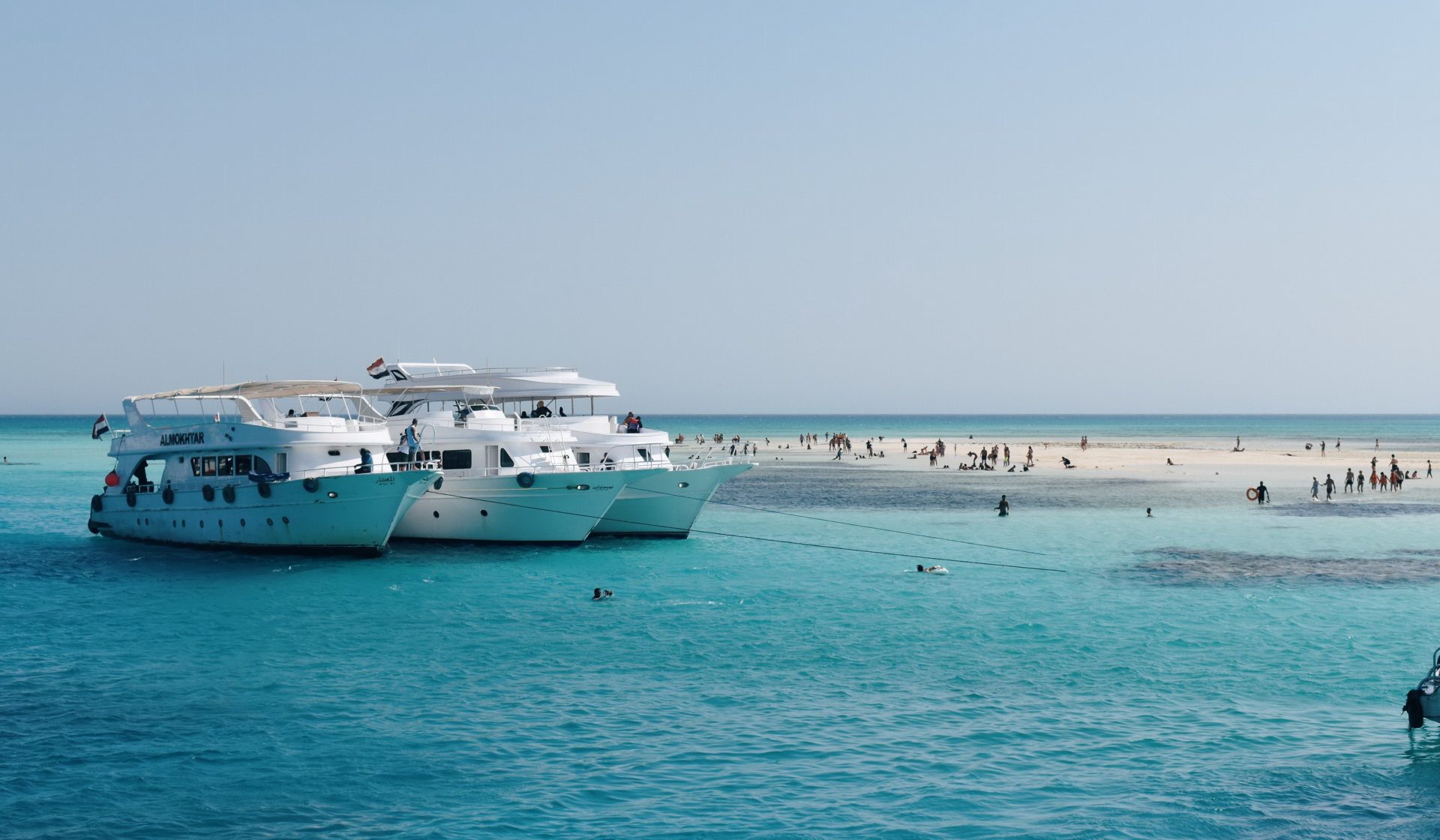 Boat beside a clear turquoise sandbank in the southern Red Sea